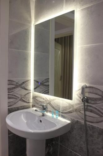 a bathroom with a white sink and a mirror at النسمة الهادئة - إقتصادى in Jeddah