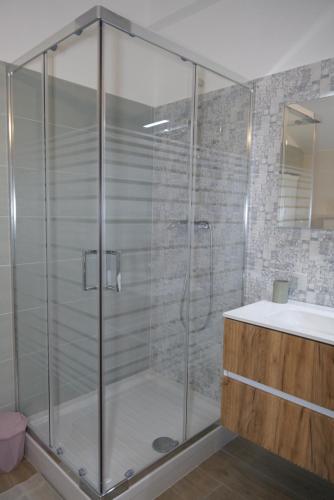 a glass shower in a bathroom with a sink at La casa di Pierre 