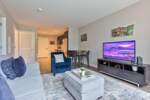 a living room with a large flat screen tv at Luxury Apt in Seaport with Gym in Boston