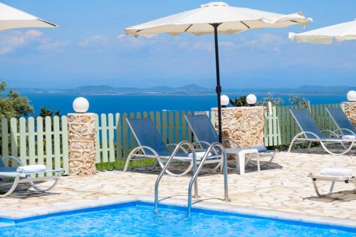 a swimming pool with chairs and an umbrella at Superior Apartment A in Tsoukaladhes