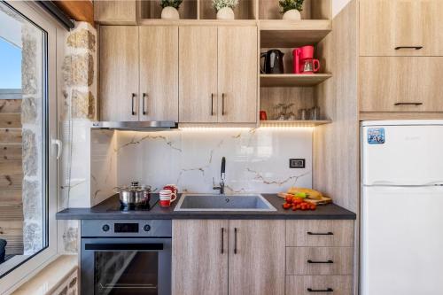 a small kitchen with a sink and a refrigerator at Superior Apartment A in Tsoukaladhes