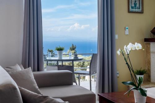 a living room with a couch and a view of the ocean at Apartment with Sea view B in Tsoukaladhes