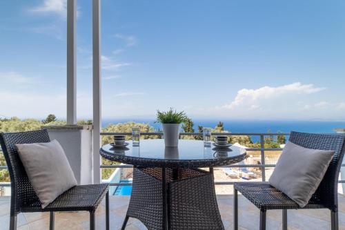 a table and chairs on a balcony with a view of the ocean at Apartment with Sea view B in Tsoukaladhes