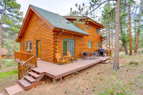 a log cabin with a deck and a table and chairs at Picturesque Log Cabin in Estes Park 9 Mi to RMNP in Estes Park