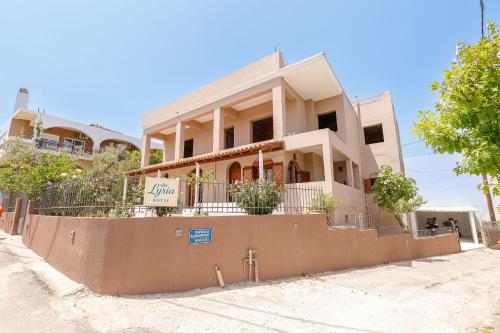 a house with a fence in front of it at Lyria Hotel Apartments in Stalos