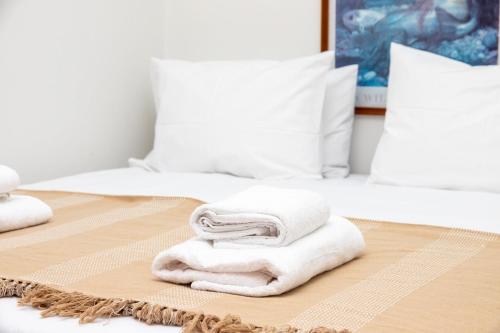 a pile of towels sitting on top of a bed at Lyria Hotel Apartments in Stalos