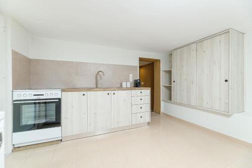 a kitchen with white cabinets and a sink and a stove at Lyria Hotel Apartments in Stalos