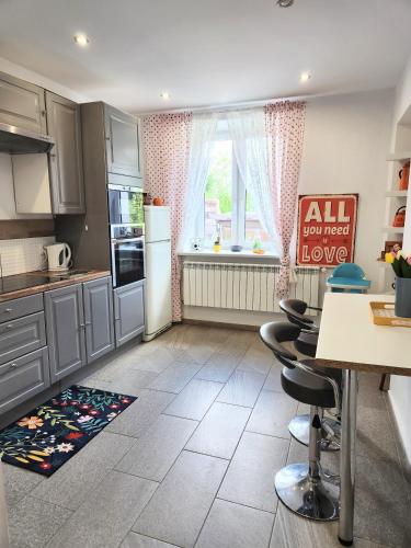 a kitchen with gray cabinets and a table and chairs at Retro House ogród prywatny parking x 2 i stacja ładowania parter in Przemyśl