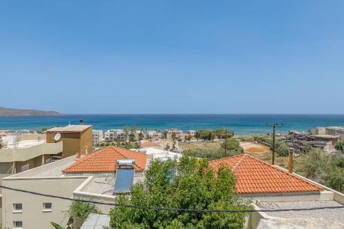 a view of a city with the ocean in the background at Lyria Hotel Apartments in Stalos