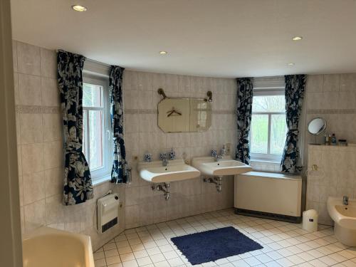 a bathroom with two sinks and a bath tub and a tubermott at Historische Mühle am Schloss in Amöneburg