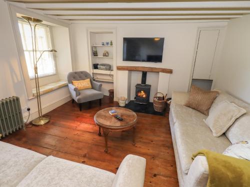 a living room with a couch and a fire place at Bridge End Cottage in Ulverston