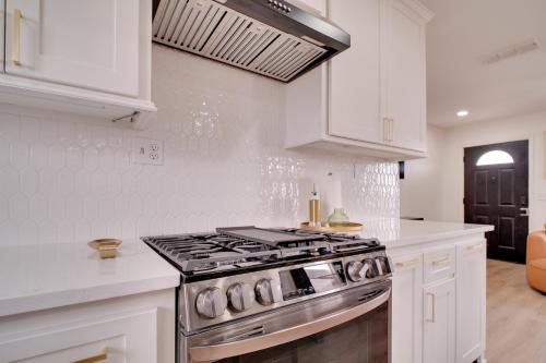 a kitchen with white cabinets and a stove top oven at 4 Mi to TTU Remodeled Retreat with Fenced Yard! in Lubbock