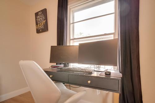 a desk with a computer and a chair in front of a window at 4 Mi to TTU Remodeled Retreat with Fenced Yard! in Lubbock