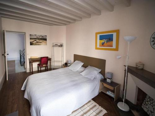 una camera con un grande letto bianco e un camino di chez Nathalie et Etienne a Saillans