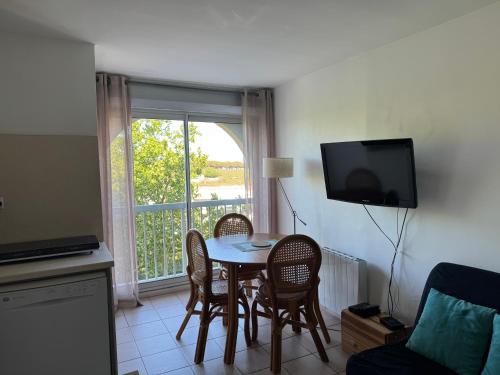 une cuisine avec une table et des chaises et une télévision dans l'établissement Studio Cosy à Carnon-Plage, à Carnon-Plage