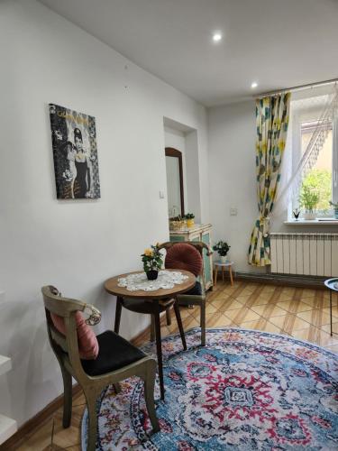 a living room with a table and chairs at Retro House ogród prywatny parking x 2 i stacja ładowania parter in Przemyśl