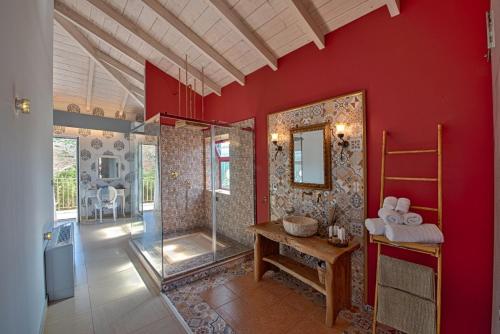 La salle de bains est pourvue d'une douche et d'un mur rouge. dans l'établissement Petani Bay Hotel - Adults Only, à Vóvikes