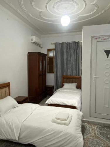 a bedroom with two beds and a ceiling at Family Lounge in Matriouene