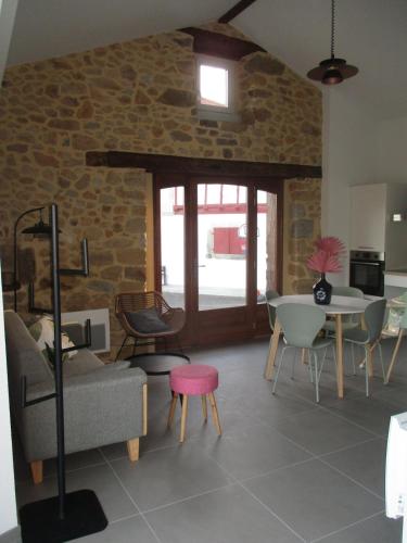 un salon avec un canapé, des chaises et une table dans l'établissement Maisonnette indépendante pour 4 personnes - PMR, à Isturits