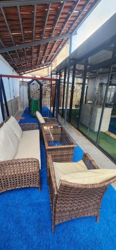 two wicker wicker beds sitting on a blue carpet at Villa dream ainturk in 'Aïn el Turk