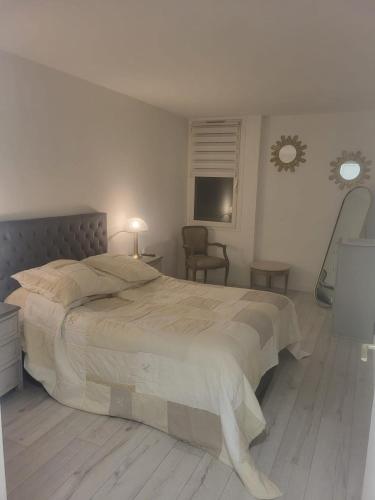 Un dormitorio con una cama grande y una silla. en Espace Forbin, en Aix-en-Provence
