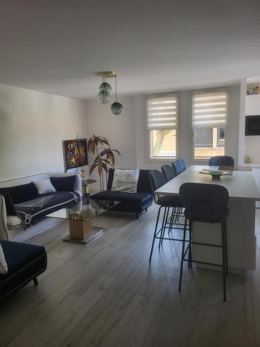 Una sala de estar con un sofá, una mesa y sillas. en Espace Forbin, en Aix-en-Provence
