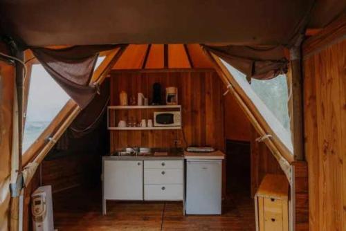- une petite cuisine dans une tente avec un four micro-ondes dans l'établissement Camping 4 étoiles - Piscine - eed0aa, à Estipouy