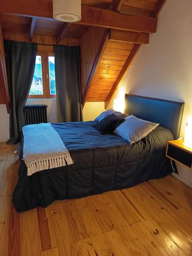 a large bed in a room with wooden floors at LOS ABEDULES in El Bolsón