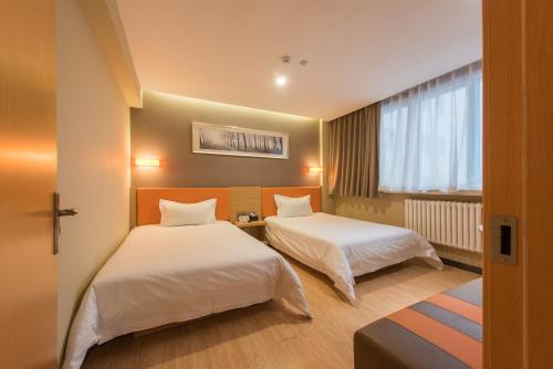 a hotel room with two beds and a window at IU Hotel Beijing West Coach Station Liuliqiao East Metro Station in Beijing