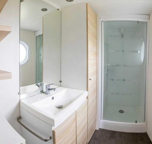 a white bathroom with a sink and a shower at Camping 5 étoiles - Parc aquatique - eebfed in Sainte-Catherine-de-Fierbois