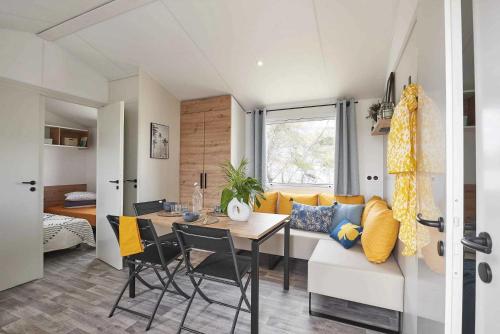 une cuisine et un salon avec une table et un canapé dans l'établissement Camping 4 étoiles - Parc aquatique - eeibed, à Vendays-Montalivet