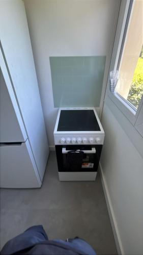 - une cuisinière dans l'angle d'une chambre avec fenêtre dans l'établissement Magnifique appartement moderne 3 chambres, à Montréjeau