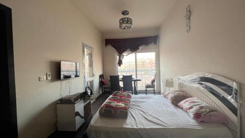 a bedroom with a bed and a desk and a window at ستوديو بورتو شرم الشيخ in Sharm El Sheikh