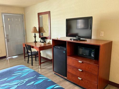 a hotel room with a television on a dresser at Hotel O Bien Venido Pearsall I-35 in Pearsall