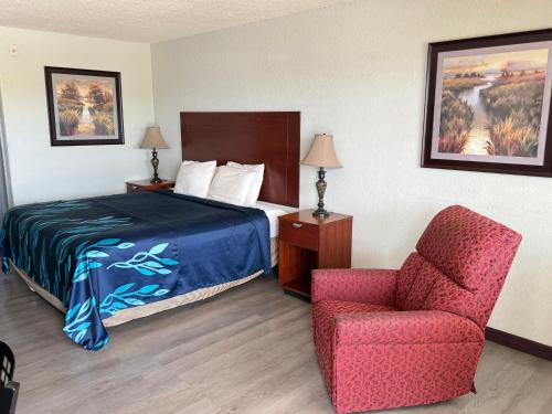 a hotel room with a bed and a chair at Hotel O Bien Venido Pearsall I-35 in Pearsall