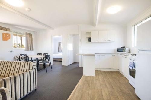 a kitchen and living room with a table and chairs at Nightcap at Golden Beach Tavern in Caloundra