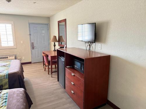 a hotel room with a television on a dresser at Hotel O Bien Venido Pearsall I-35 in Pearsall