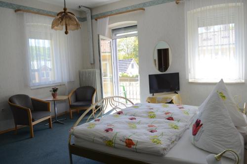 a bedroom with a bed and a tv in a room at Pension Haus Marga in Bad Kissingen