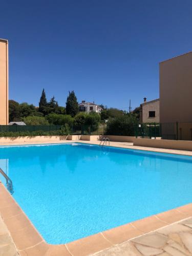une grande piscine bleue dans un immeuble dans l'établissement Lumineux avec piscine, Wifi & Terrace - Proche plage & Aéroport, à Saint-Laurent-du-Var