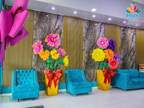 a lobby with blue chairs and flowers in vases at Ayenda 1132 Copiclub in Ibagué