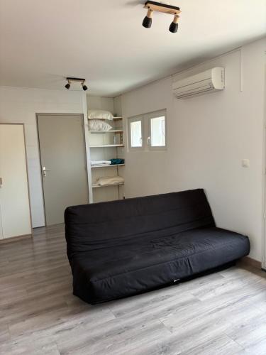 un canapé-pouf noir dans une pièce avec dans l'établissement Villa playa, à Valras-Plage