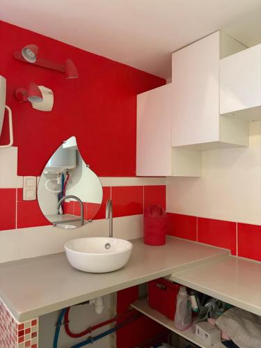 une cuisine avec des murs rouges et un évier blanc dans l'établissement Villa playa, à Valras-Plage