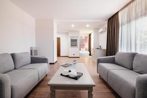 ein Wohnzimmer mit zwei Sofas und einem Couchtisch in der Unterkunft Charos Family Resort in Yusufkhona