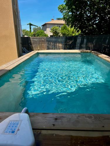 une piscine avec de l'eau bleue dans une cour dans l'établissement Duplex piscine 3 chambres et Clim proche plages, à Villeneuve-lès-Maguelone