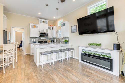 a kitchen with a bar with stools and a flat screen tv at Lake-View Home with Pool Access in Sherrills Ford! in Sherrills Ford