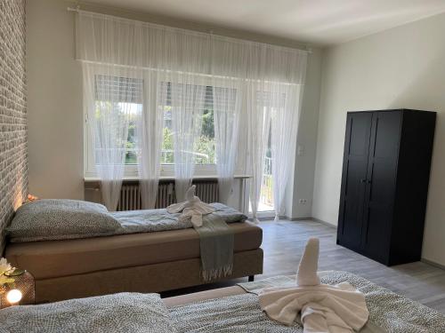 a bedroom with a bed and a window with white curtains at Cozy Private Rooms in Wesseling in Wesseling