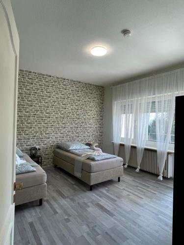 a bedroom with two beds and a brick wall at Cozy Private Rooms in Wesseling in Wesseling