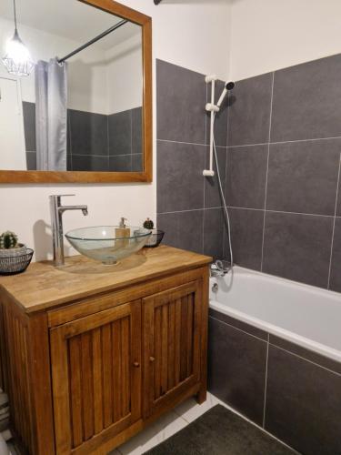 a bathroom with a sink and a tub and a mirror at Appartement 37 m2 avec balcon in Berck-sur-Mer