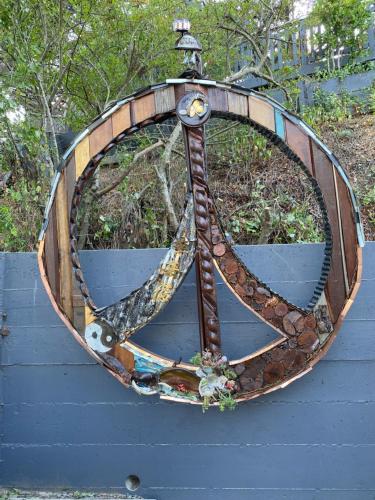 a circular metal sculpture of a bike on a wall at Bridge Street Beauty in Cambria