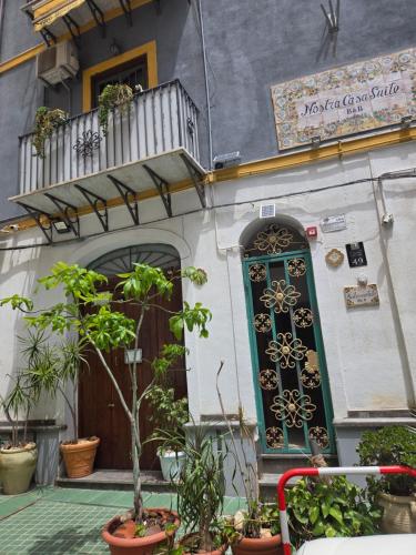 un edificio con una puerta verde y algunas plantas en Nostra casa rooms, en Palermo